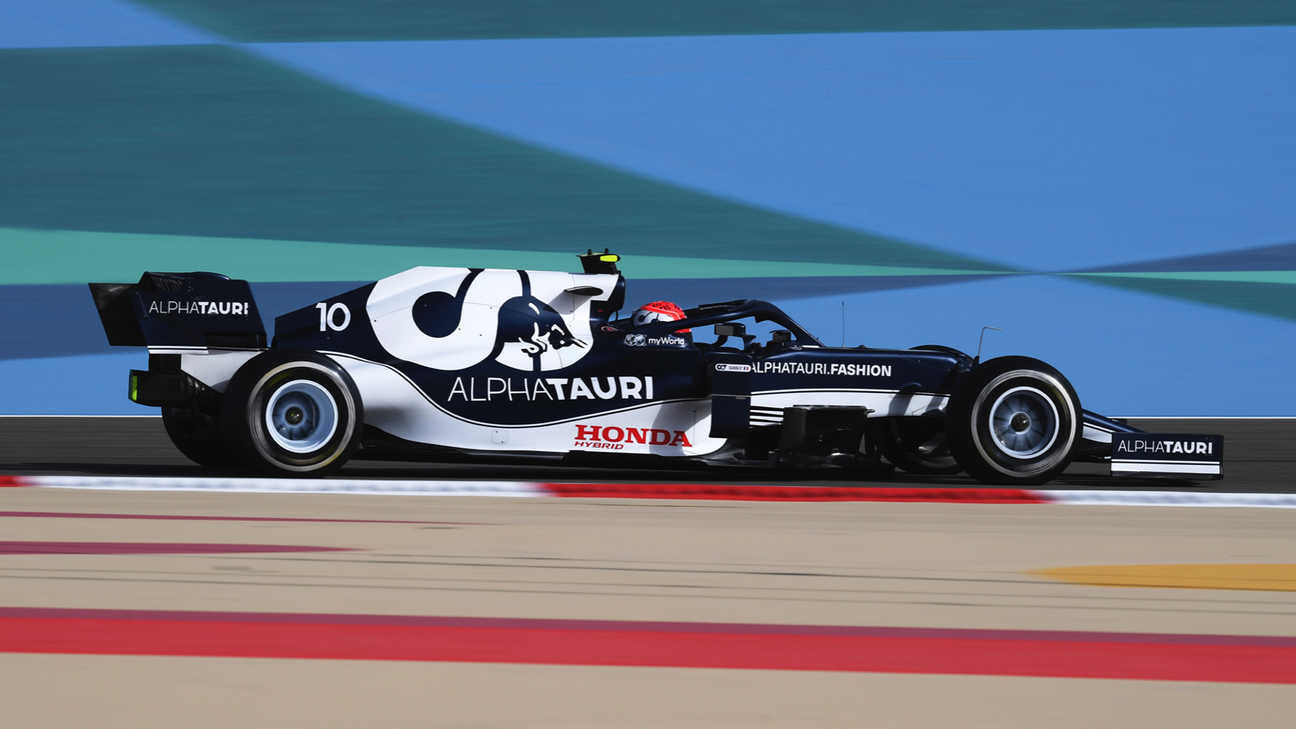 Scuderia Alphatauri enginner in the pit lane holding a tire