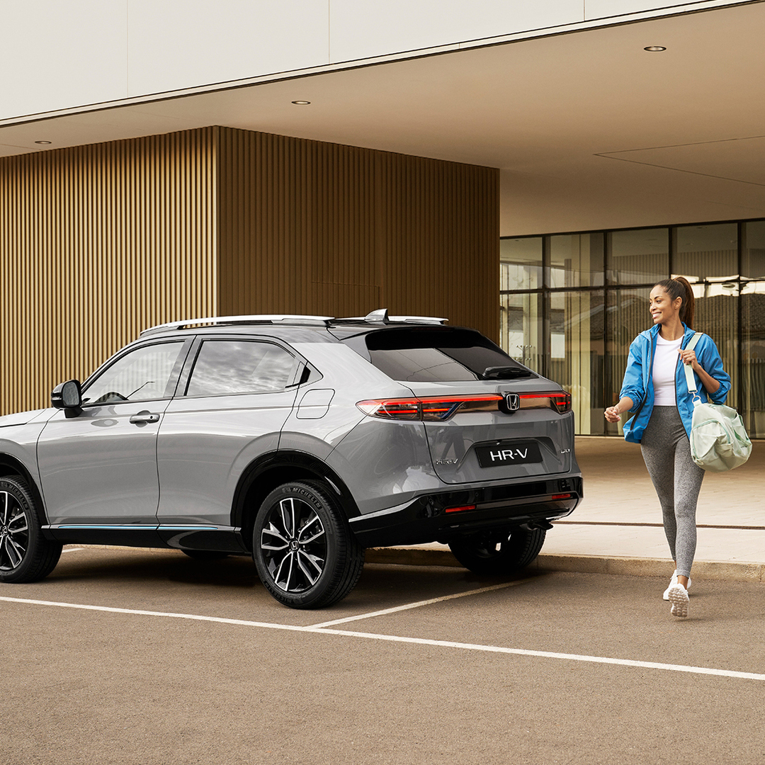 Woman walking allongside parked HR-V. 