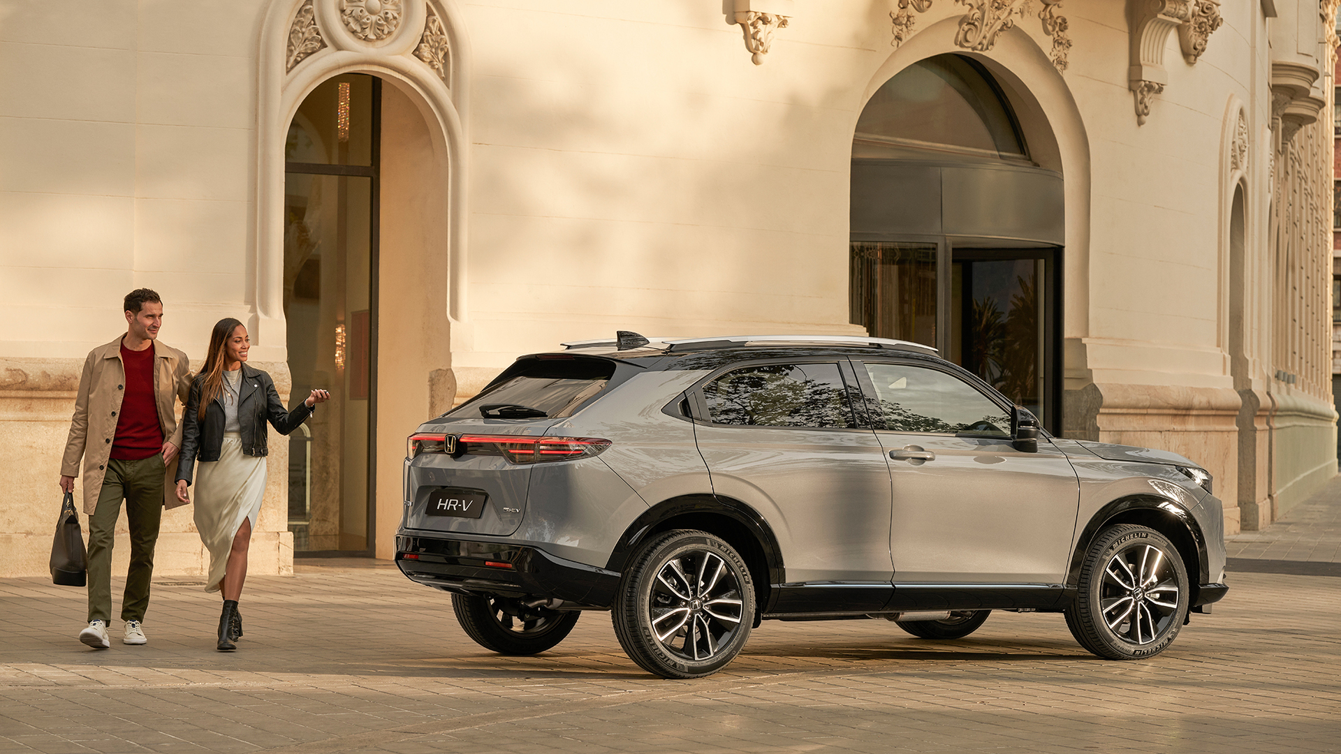 Couple walking next to  HR-V parked outside of building location. 