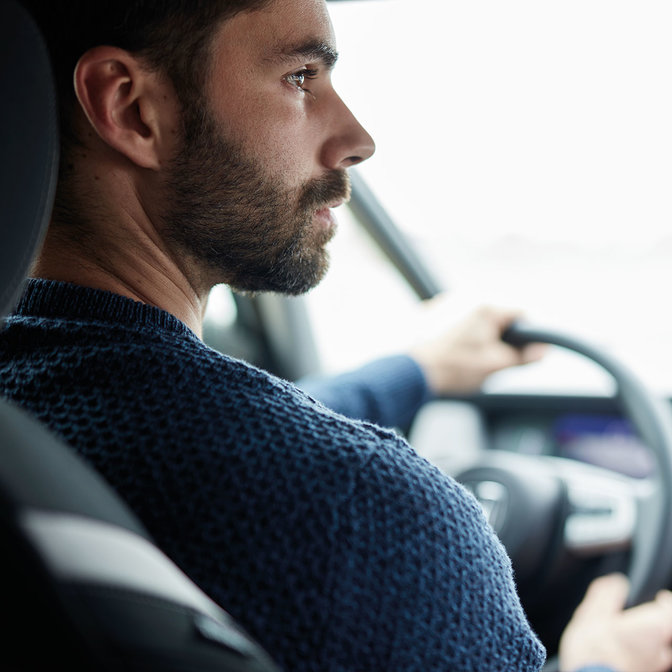 close of man driving Honda Jazz