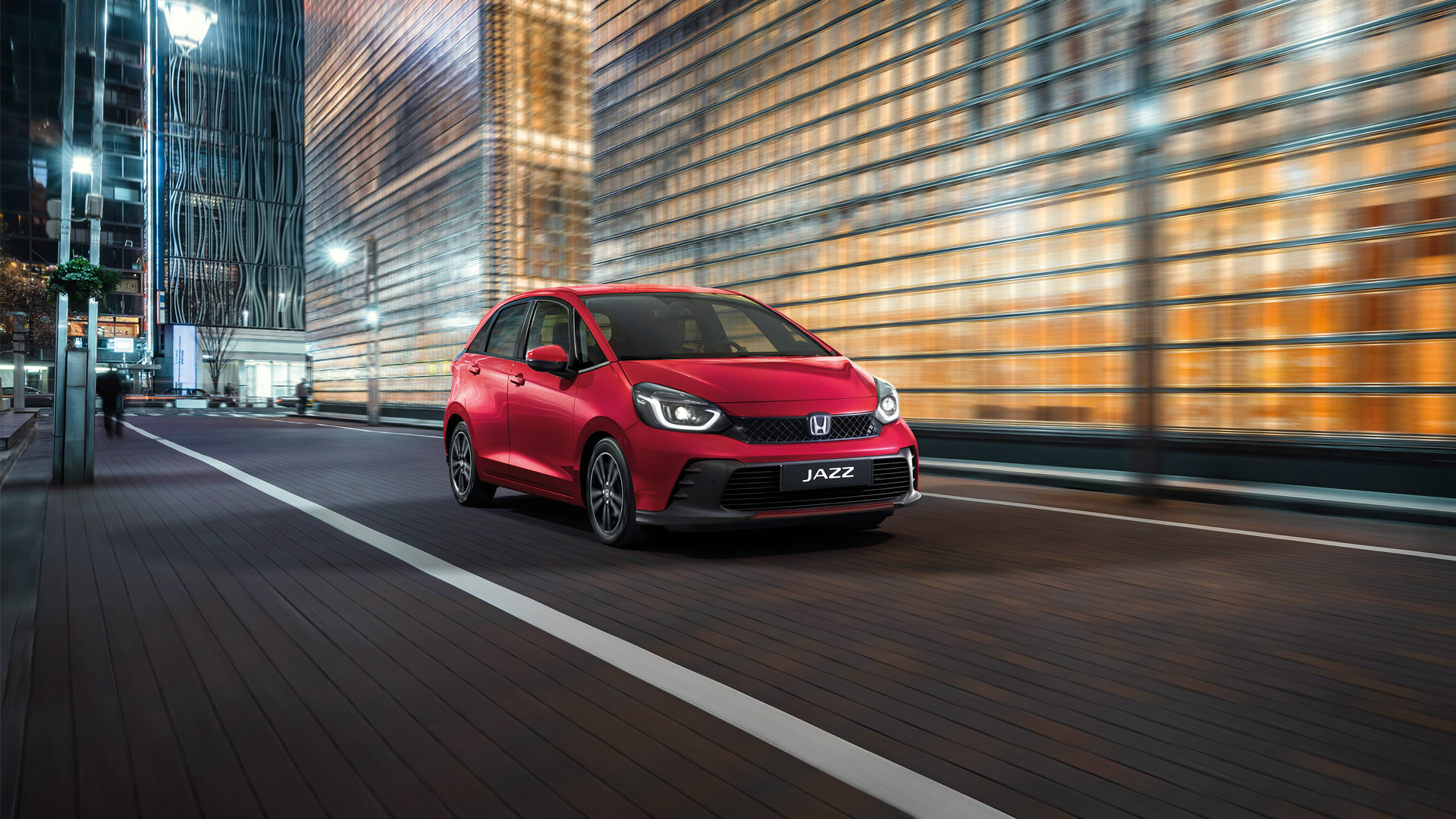 Front facing 3/4 Honda Jazz in front of city background.