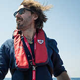 Close up of Man in a Life jacket outside in the sunshine.