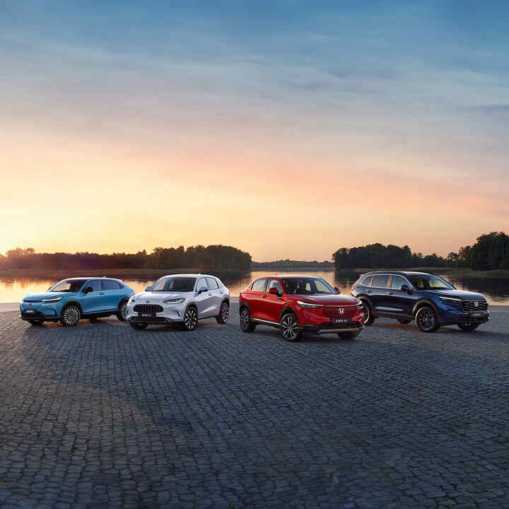 SUV range all parked together by a lake