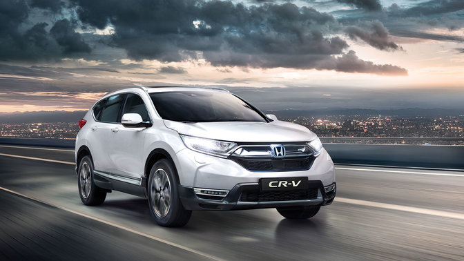 Front three-quarter facing Honda CR-V with high beam headlights on