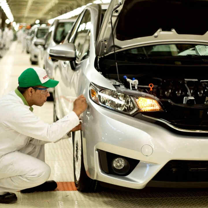 Honda technician working on a car in the factory.