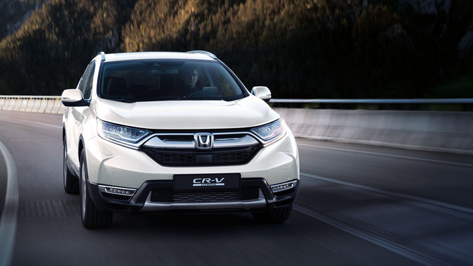 Front facing Honda CR-V driving through mountain location.