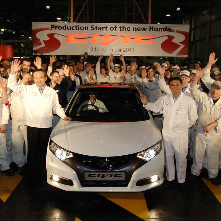 Front facing Honda Civic 5 door with workers.