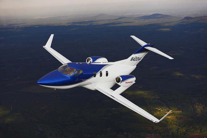 Honda Jet flying over mountains.