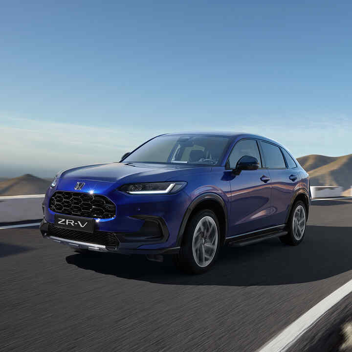 Front three quarter Honda ZR-V with robust pack in mountainous location.