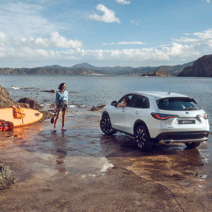 White ZR-V by the coast with woman and canoe