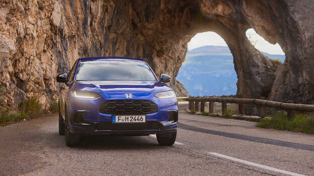 ZR-V Hybrid SUV blue sporty powertrain driving in mountain road location.