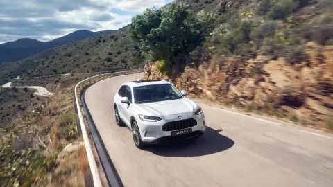 Front facing ZR-V Hybrid driving in a mountainous location.