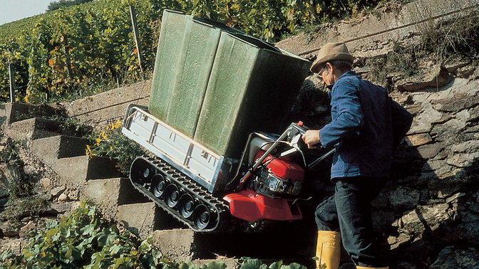 Honda power carrier being used by man on steps to move heavy load