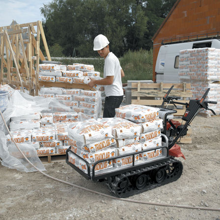 Honda power carrier beng used on a construction site by a man in white t-shirt and safety helmet