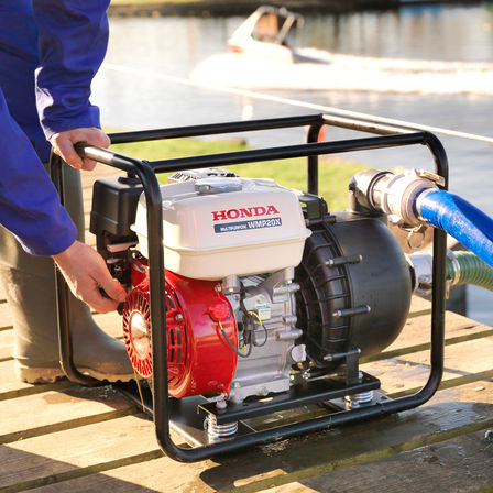 Close up of high flow rate/chemical water pump being used by a man on decking