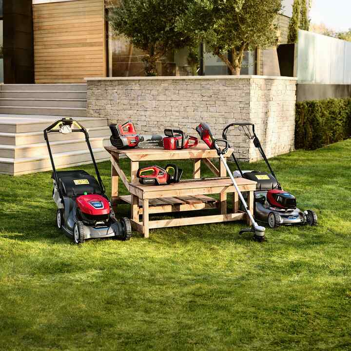Woman using hedtrimmer in garden