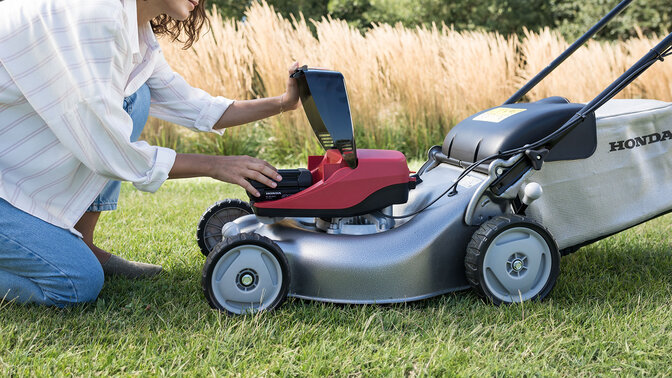 Woman using leafblower in garden