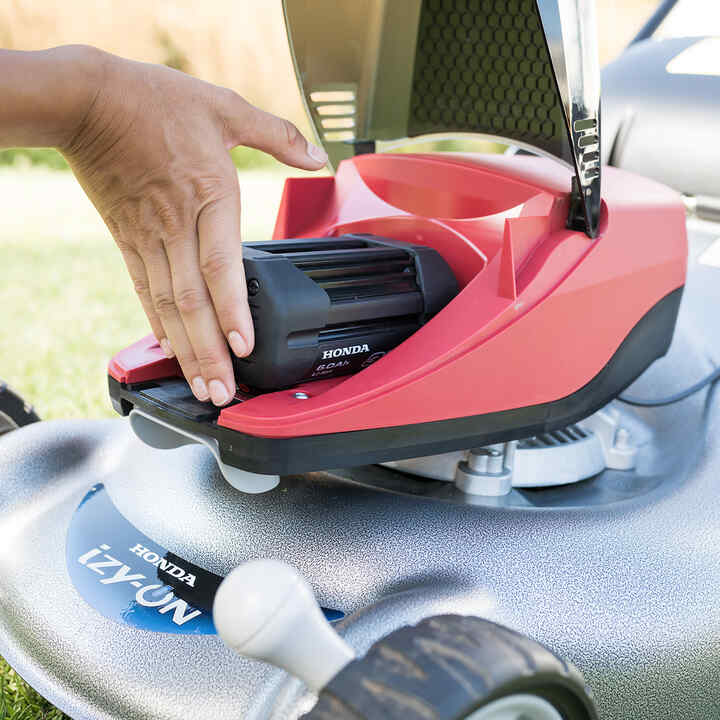 A man fixing together a cordless hedgetrimmer