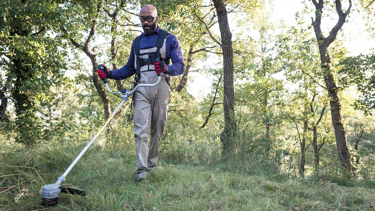 front side view of man cutting long grass with honda cordless brushcutter