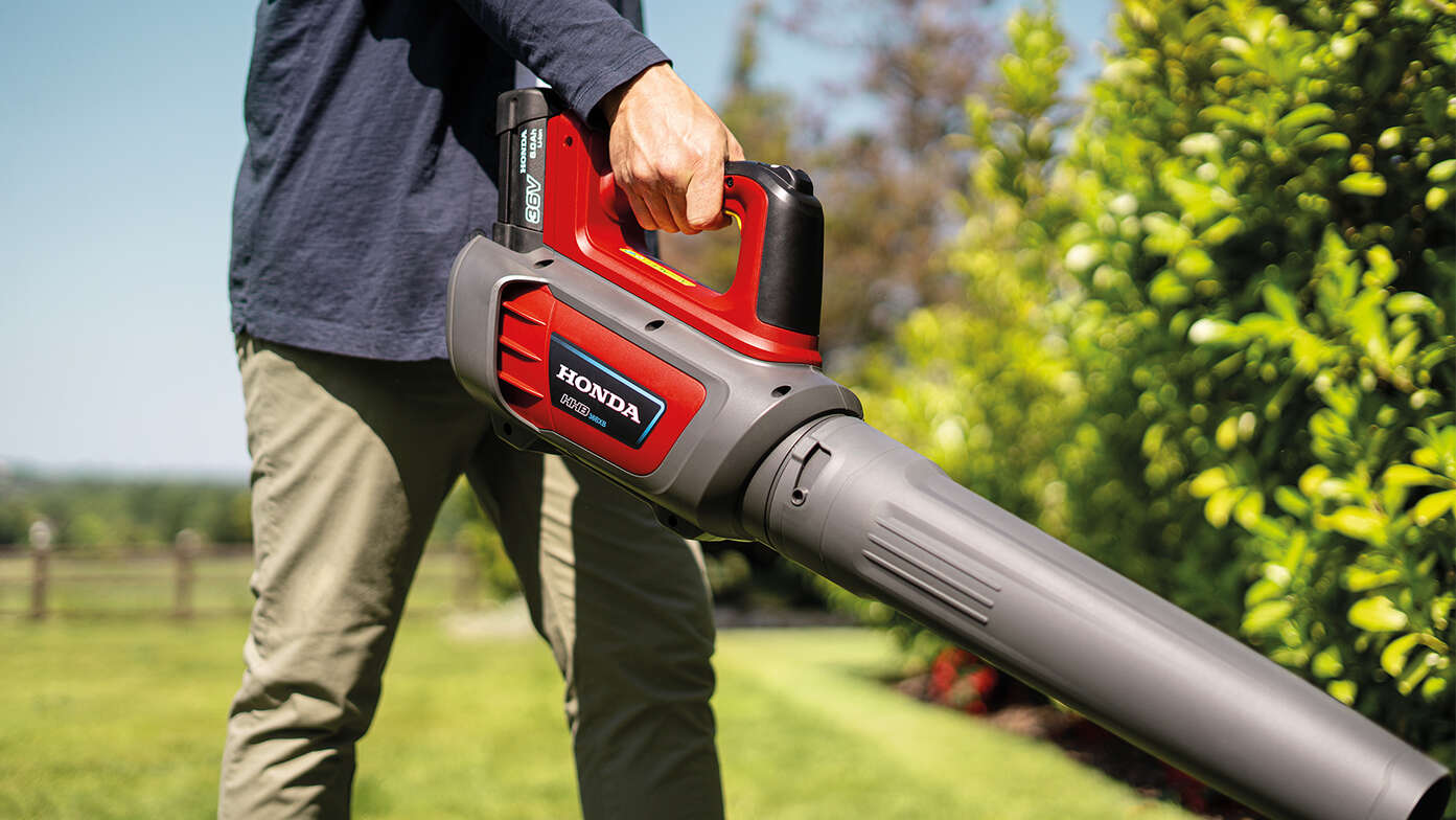 Man holding and using a Cordless Leafblower