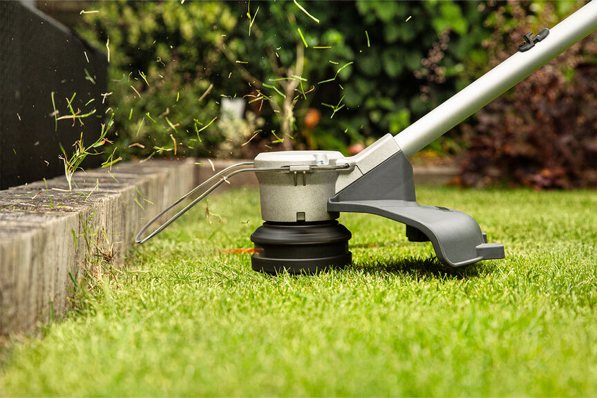 Cordless lawntrimmer demonstrating high quality cutting line on lawn.