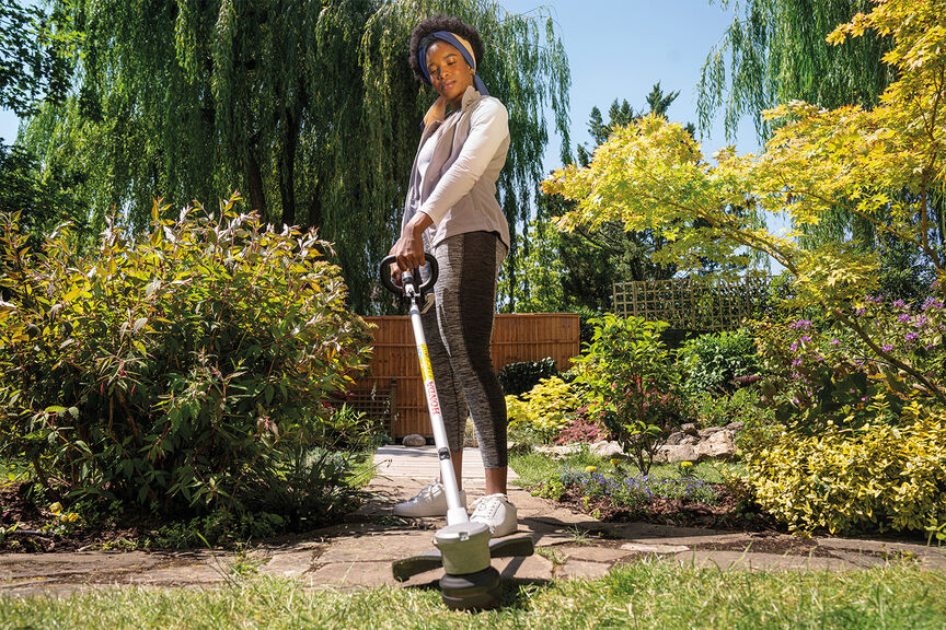 Cordless lawntrimmer demonstrating high quality cutting line on lawn.