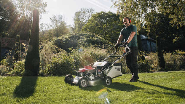 Man pushing Honda HRH in garden location