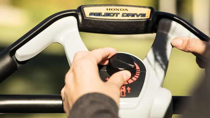 close up view of someone operating select drive controls of honda hrx petrol lawnmower