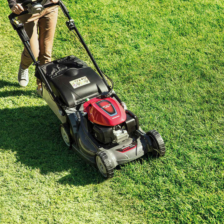 top angled view of person mowing lawn with honda hrx petrol lawnmower