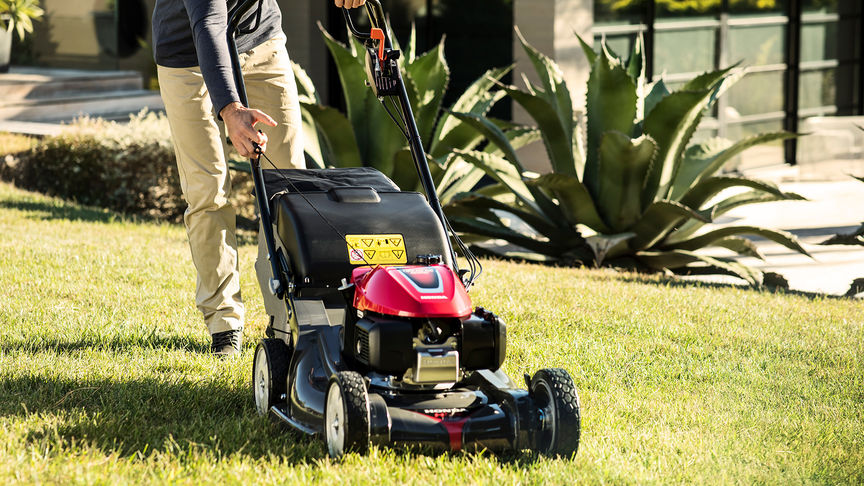 front side view of person mowing grass with honda hrx petrol mower