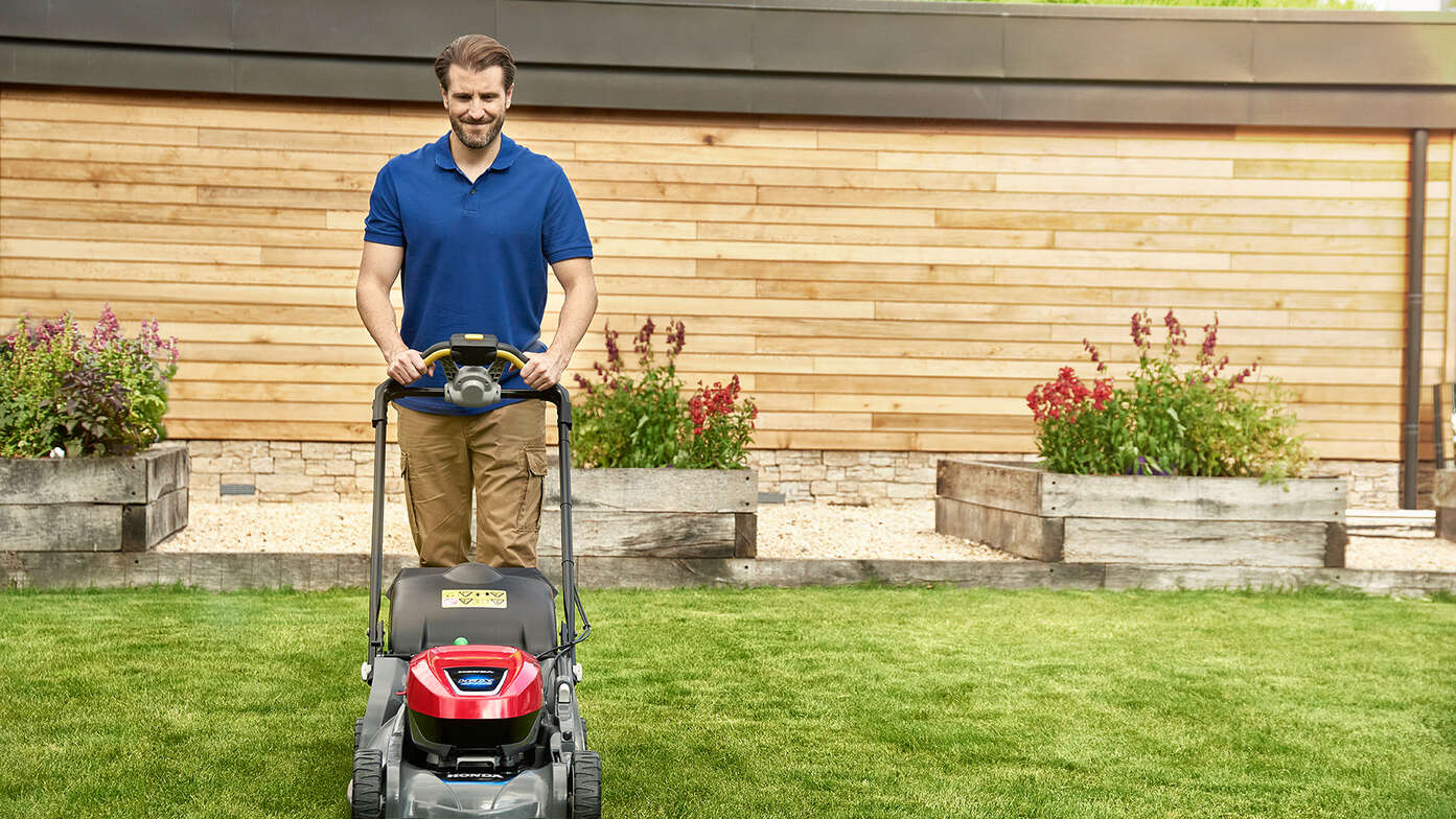 Man pushing Honda HRX in garden location