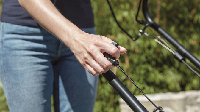 close up on woman operating honda izy petrol lawnmower controls