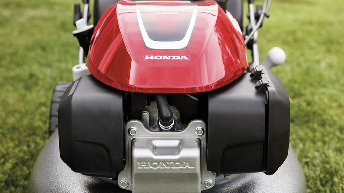 front close up view of honda izy petrol lawnmower on grass
