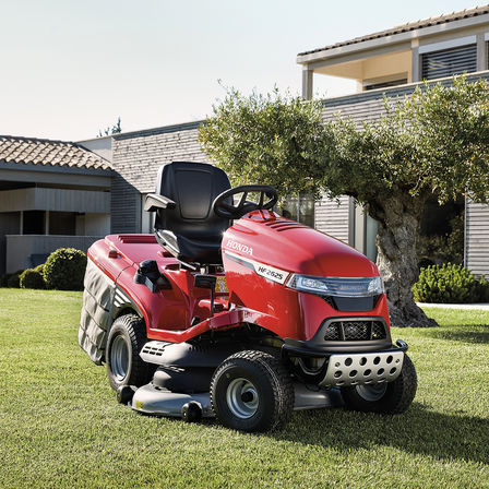 Front three-quarter view Honda tractor in a garden with house at the background