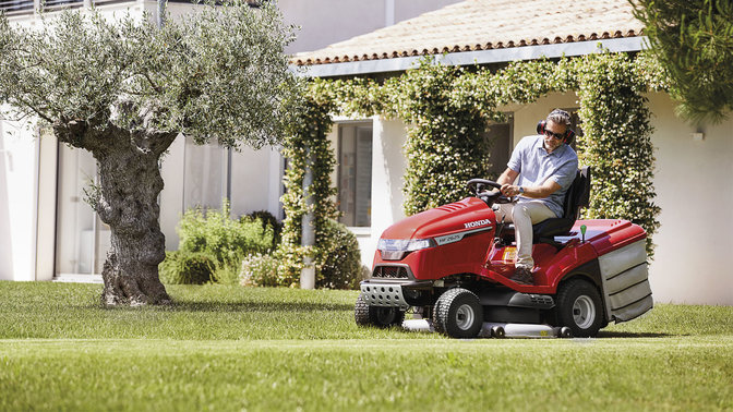 A man riding a lawn tractor and mowing the grass