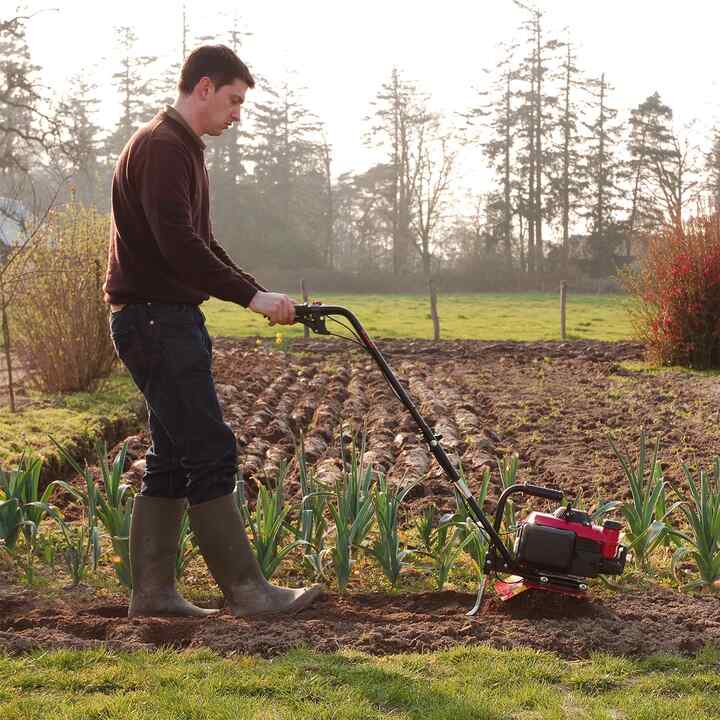 Right facing Honda Micro Tiller in use in a field.