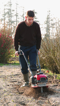 Honda microtillers, being used by model, on location.