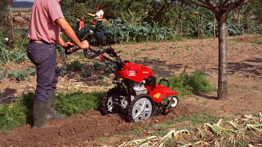 Front facing rotary tiller working on the land.