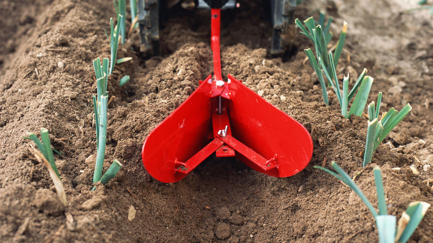 Front facing rotary tiller working on the land.