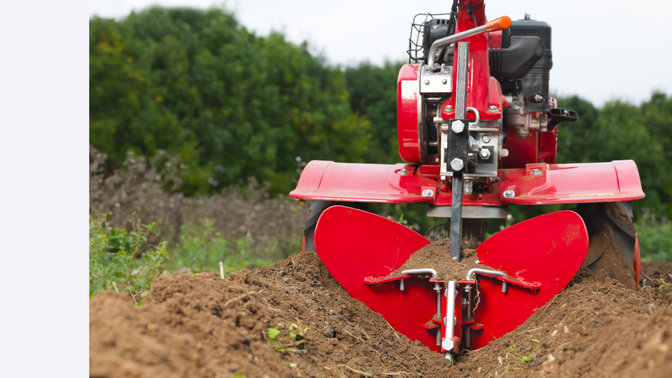 Close up of versatile tiller, garden location.