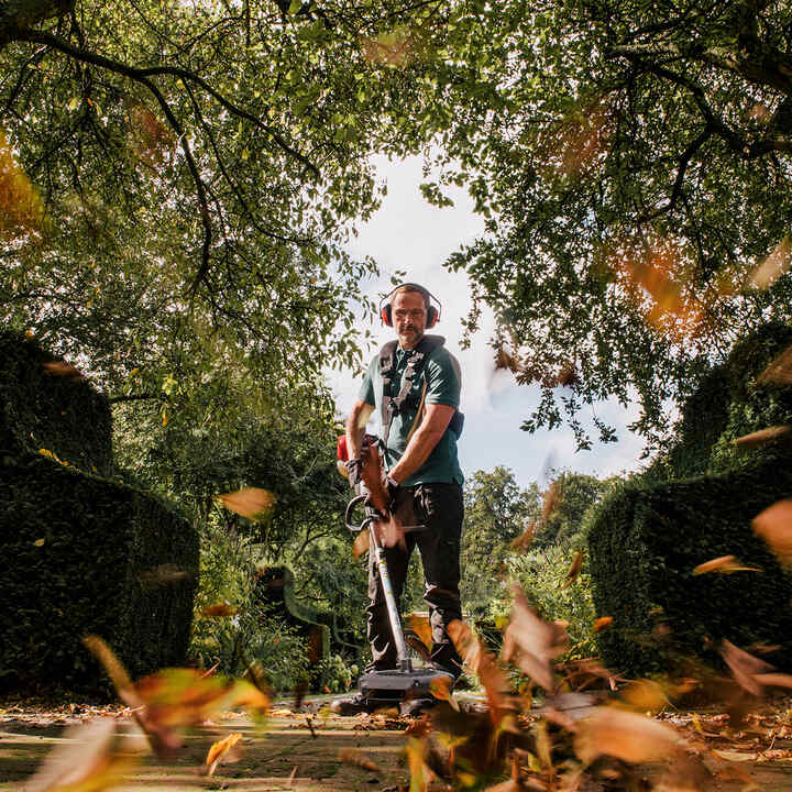 Man using Versatool to clear leaves