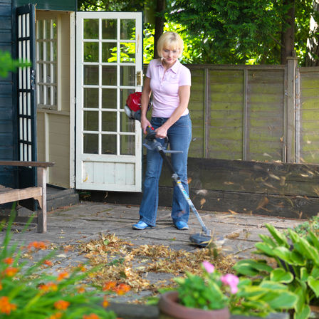 Honda Versatool with leaf blower attachment, being used by model, garden location.