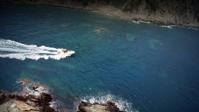 Aerial view of boat steering through the sea.