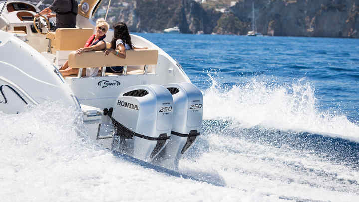 Boat using Honda V6 range engine, being used by models, coastal location.