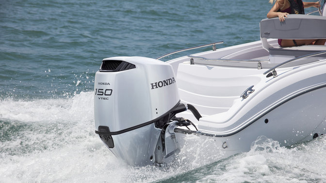 side view of couple steering boat powered by honda marine engines