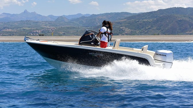 side view of couple steering boat powered by honda marine engines