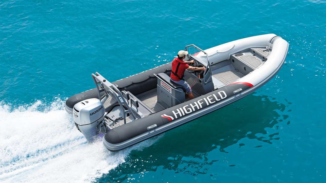 angled aerial of man steering highfield boat powered by a honda outboard engine