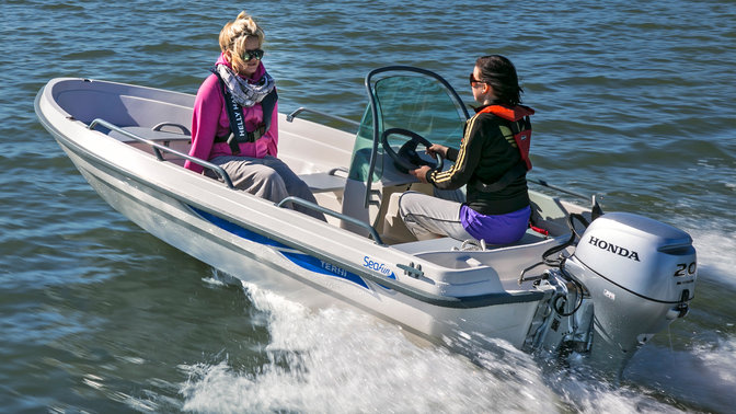 side angled view of two women steering boat fitted with honda outboard engine