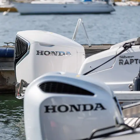 Group of people diving off Honwave with a Honda enging in lake location.