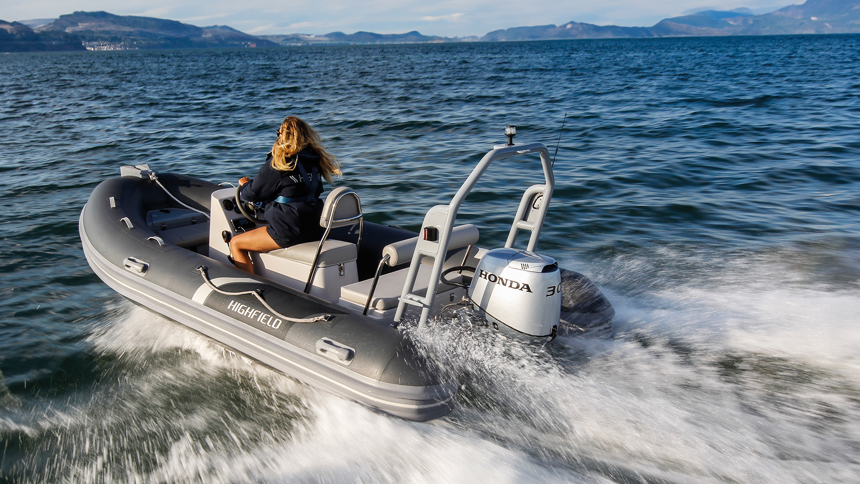 Lady on a highfield boat with a Honda BF30 engine in ocean location.